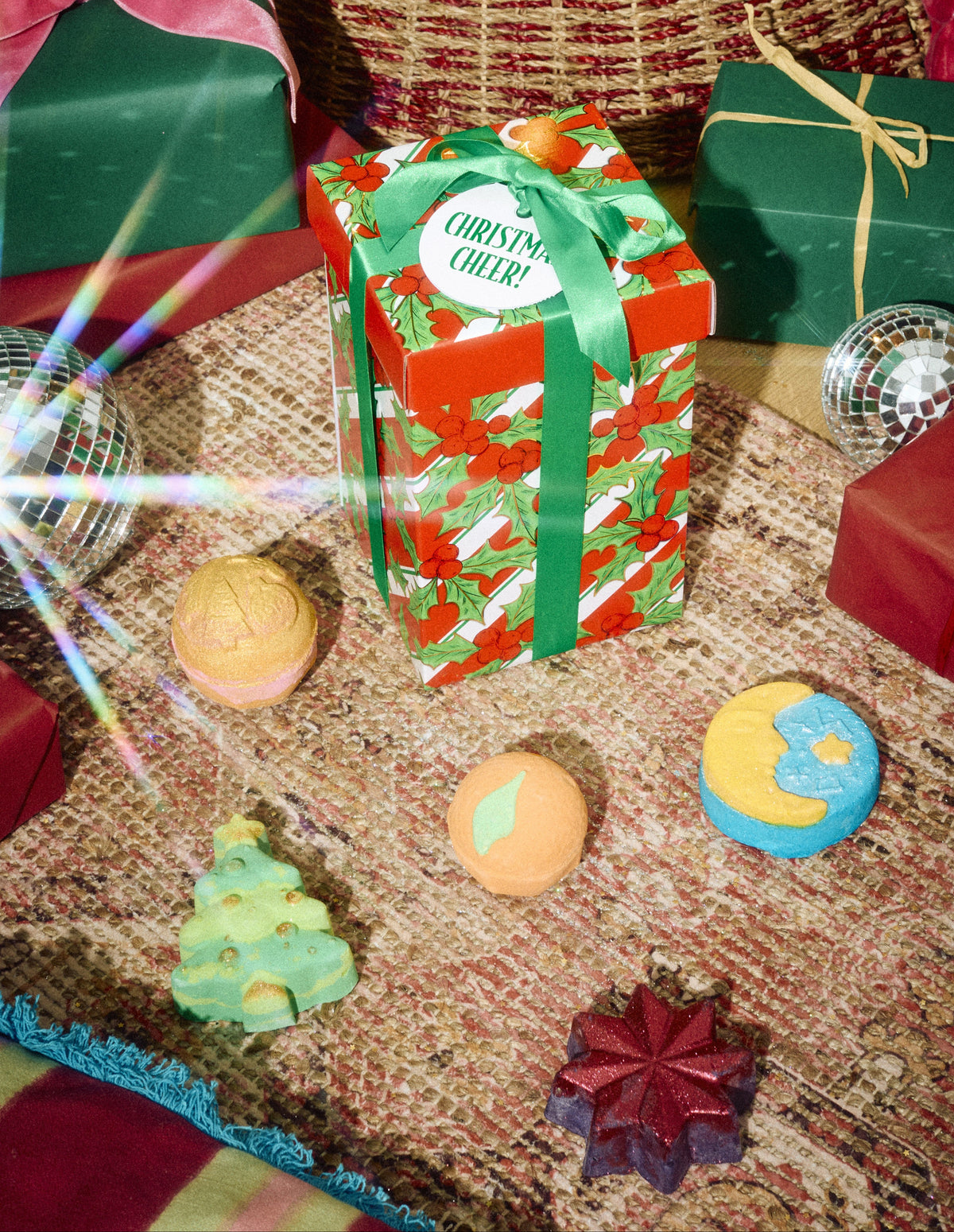 Christmas Cheer! wrapped gift displayed with colourful bath products beneath a Christmas tree.