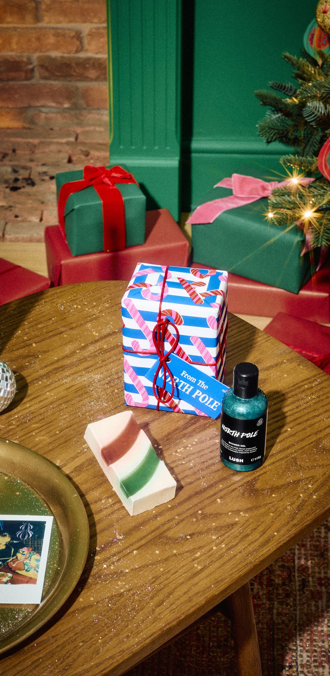 From the North Pole gift displayed with a shower gel bottle and striped solid product on a wooden table.