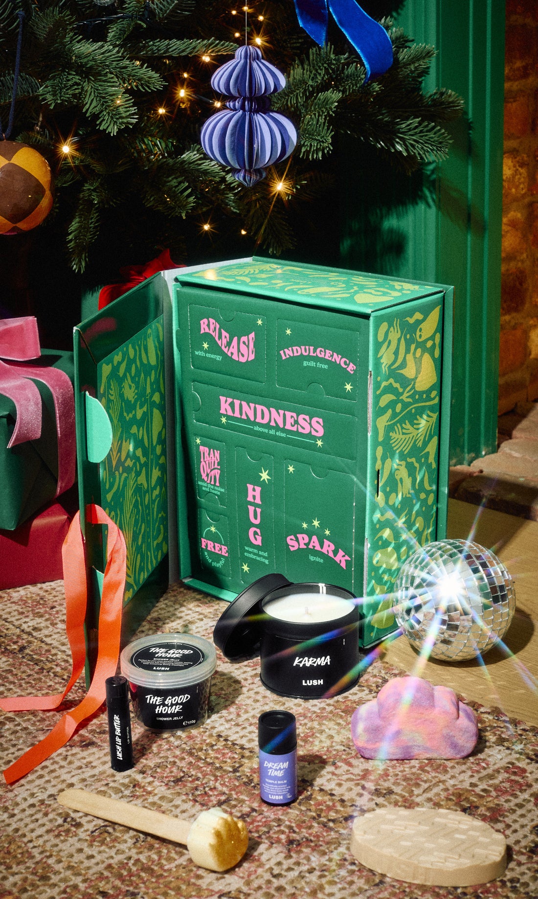Mindful Moments green gift box surrounded by its bath and body products beneath a Christmas tree.