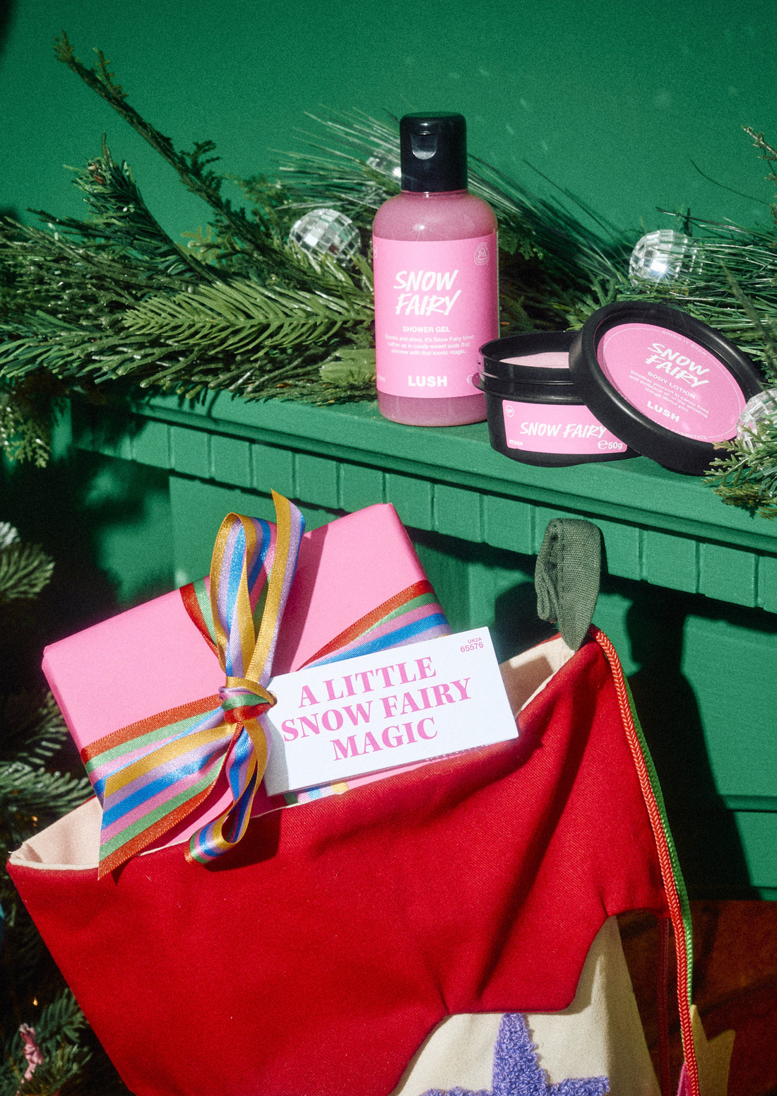 A Little Snow Fairy Magic gift in a stocking, with a pink bottle and open pot on the mantelpiece.