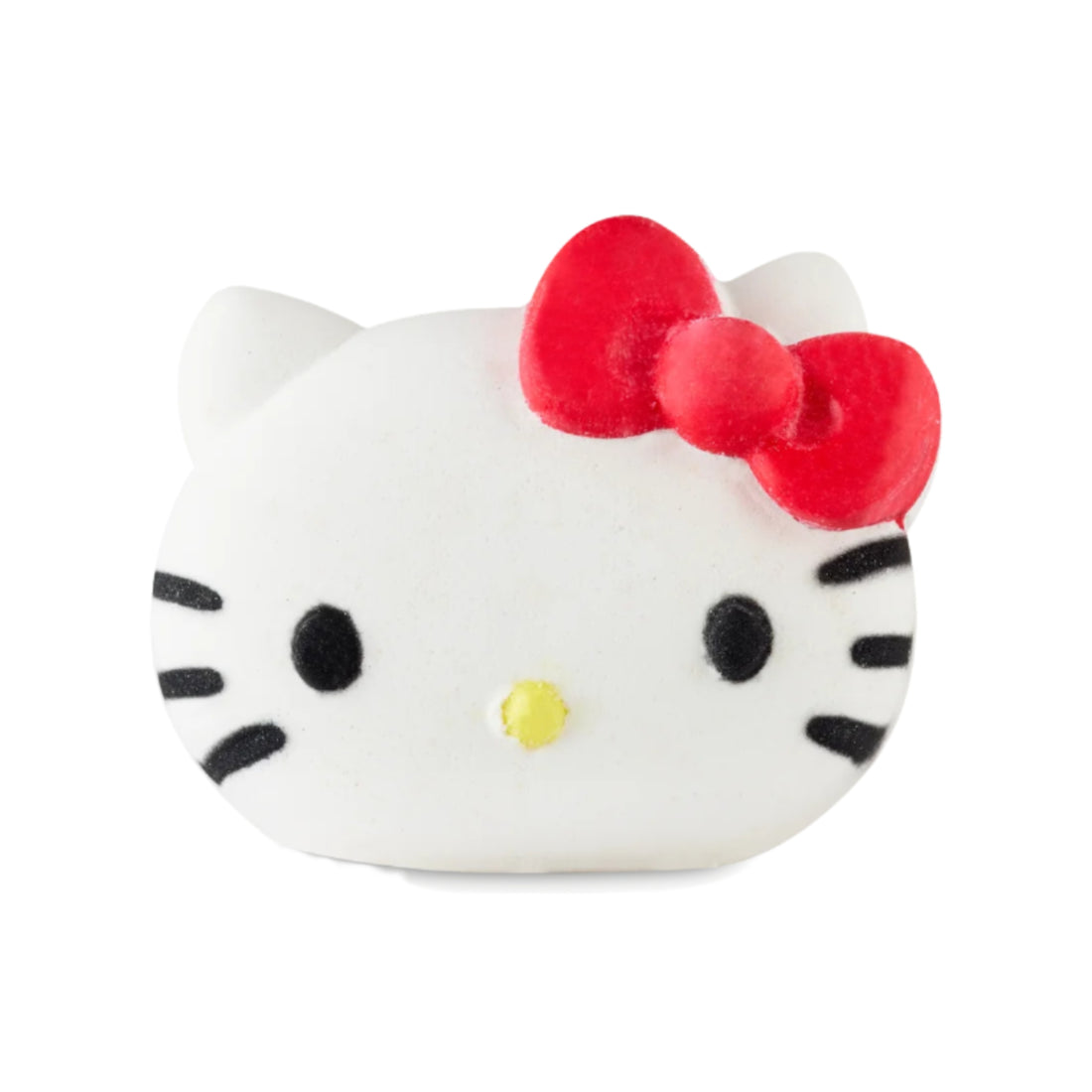 Hello Kitty-shaped white bath bomb with black facial features, a yellow nose, and a red bow.