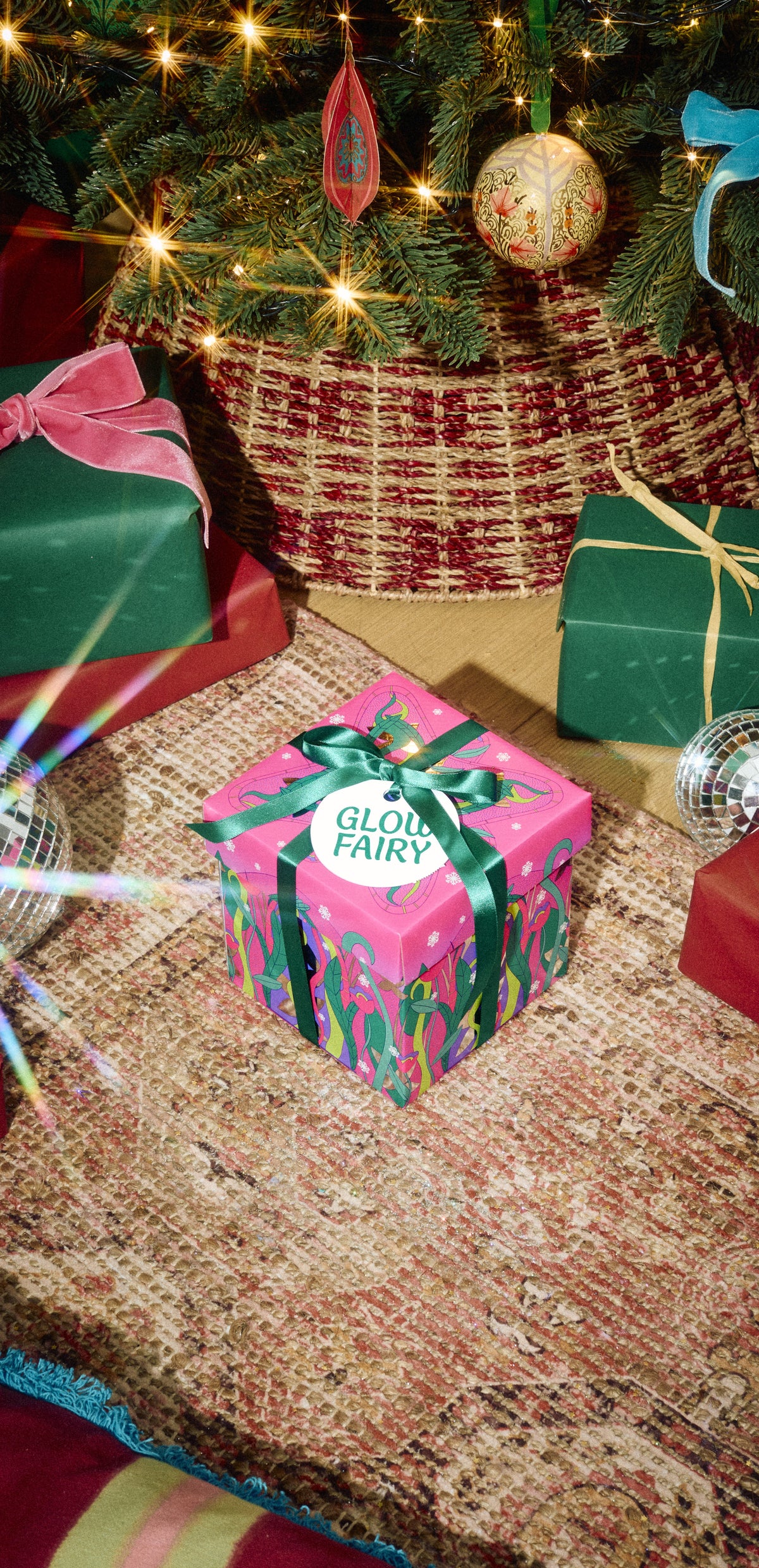 Glow Fairy gift in pink-and-green wrapping with a green ribbon beside Christmas presents.