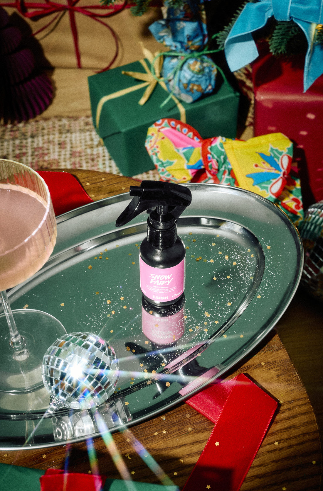 Snow Fairy body spray in a black trigger bottle with a pink label on a silver tray.