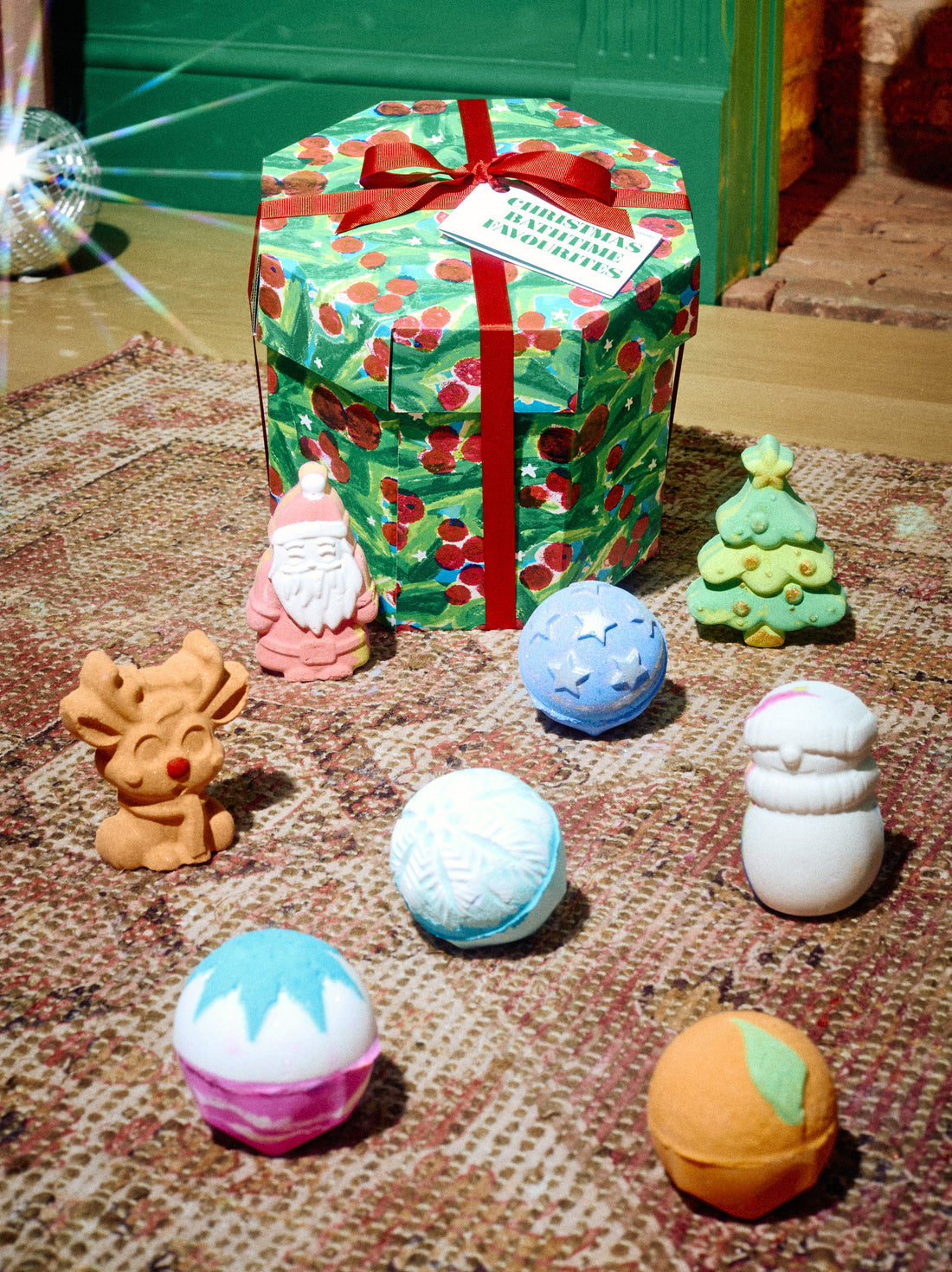 Christmas Bathtime Favourites gift box surrounded by colourful bath bombs in festive shapes.