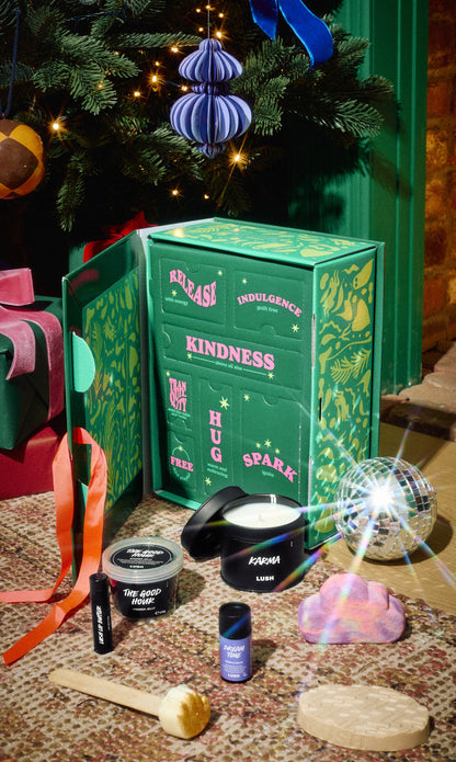 Mindful Moments green gift box surrounded by its bath and body products beneath a Christmas tree.