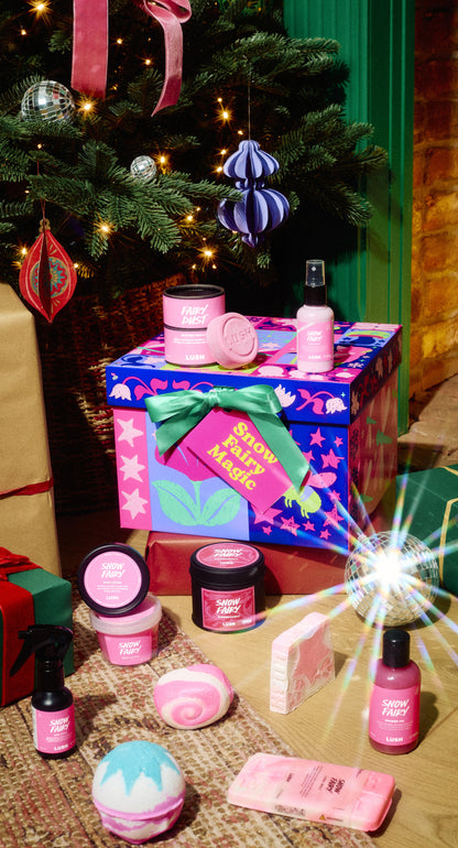 Snow Fairy Magic gift box displayed with a range of pink bath and body products beneath a Christmas tree.