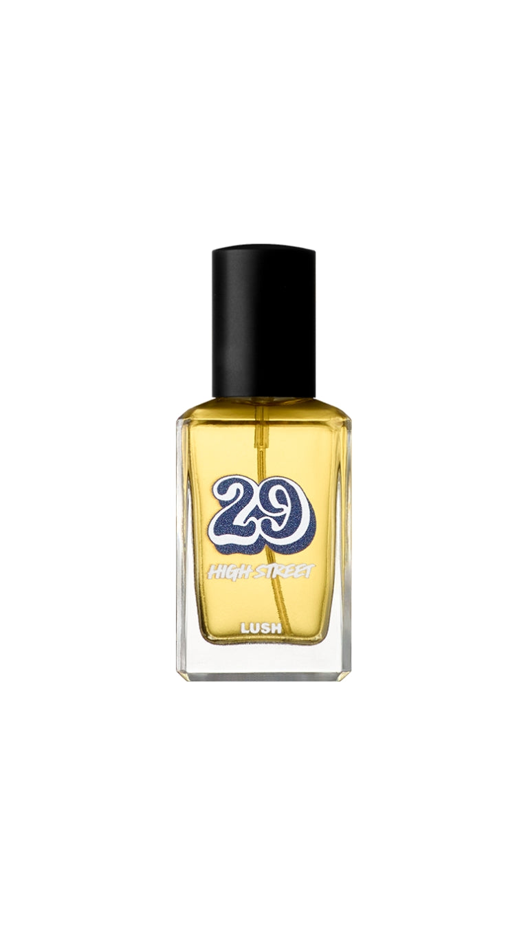 A clear glass bottle with  yellow liquid inside, topped with a black lid and the number 29 printed on the front. 