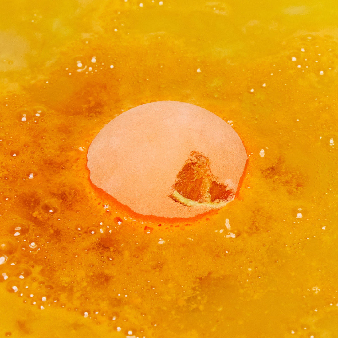 The One With The Orange Slices is slowly dissolving in the bath creating a thick, bubbly blanket of bright orange foam.