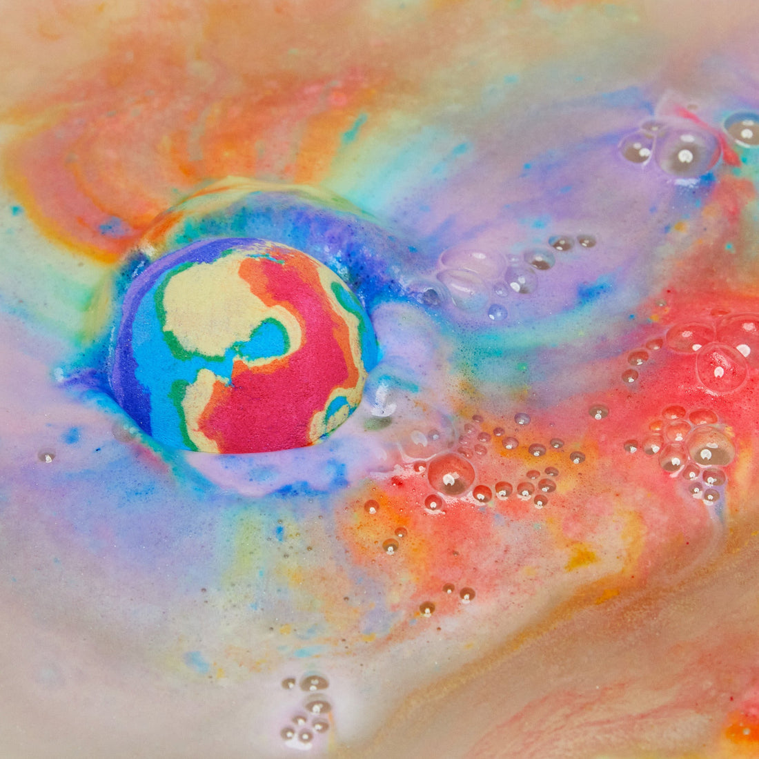 The thermal Waves bath bomb is dissolving leaving behind a thick, velvety blanket of bright rainbow swirls across the surface of the water.