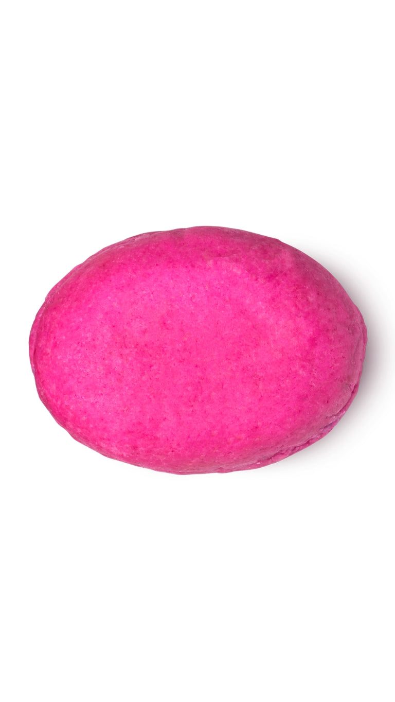 A pink oval-shaped lush conditioner bar that smells like strawberries.
