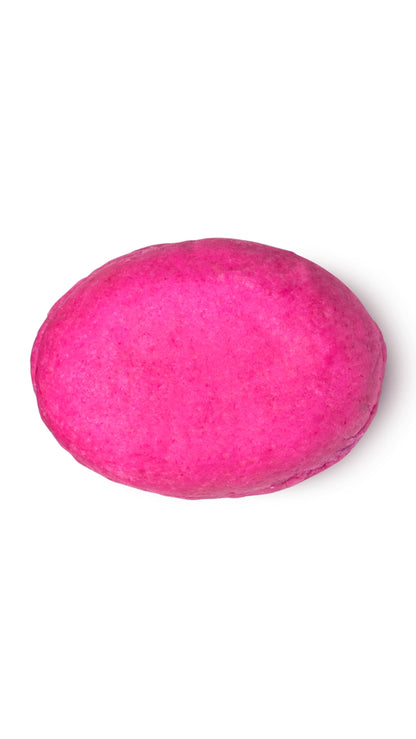 A pink oval-shaped lush conditioner bar that smells like strawberries.