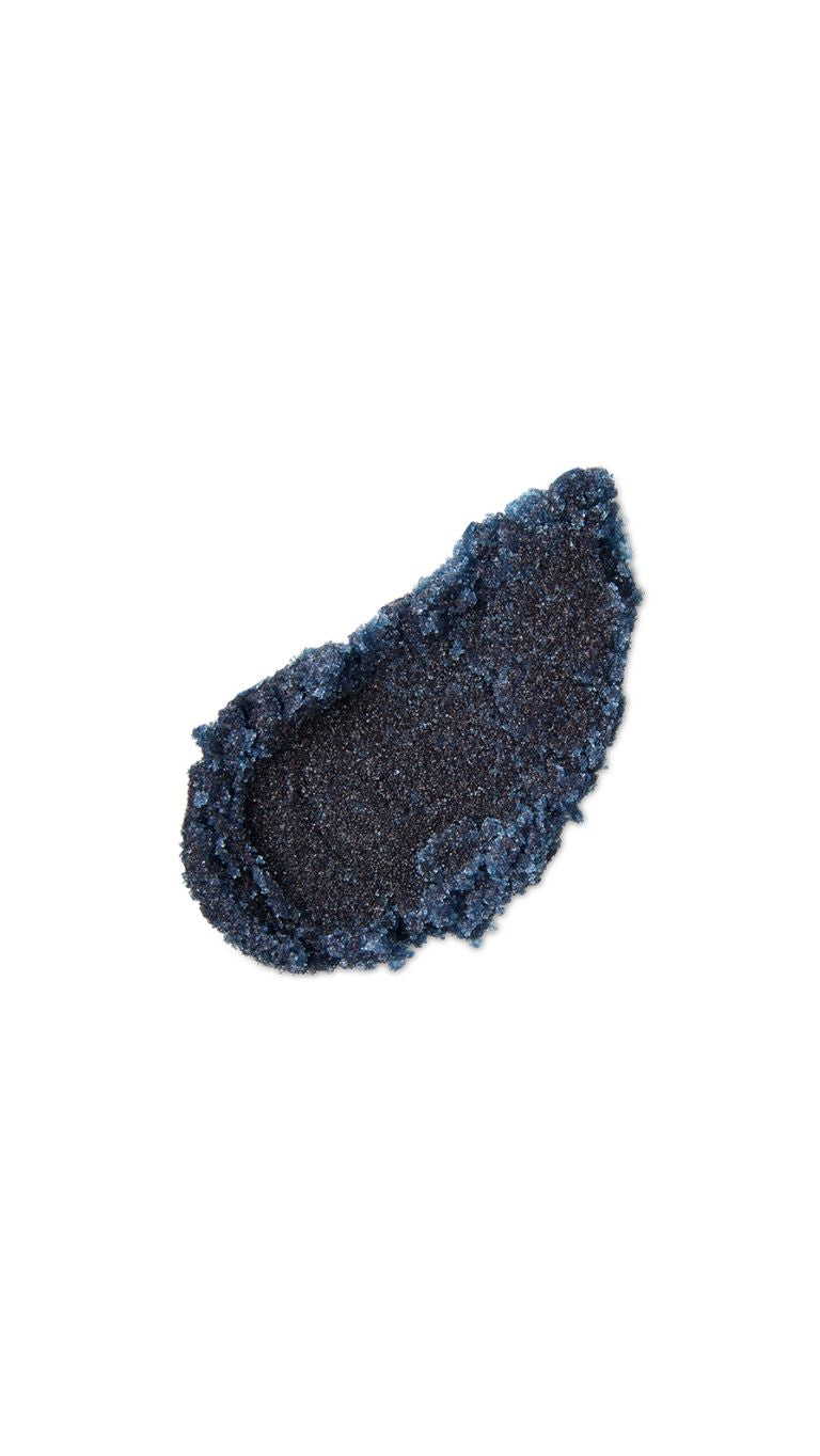 A black tear-shaped swatch of a lush lip scrub. 