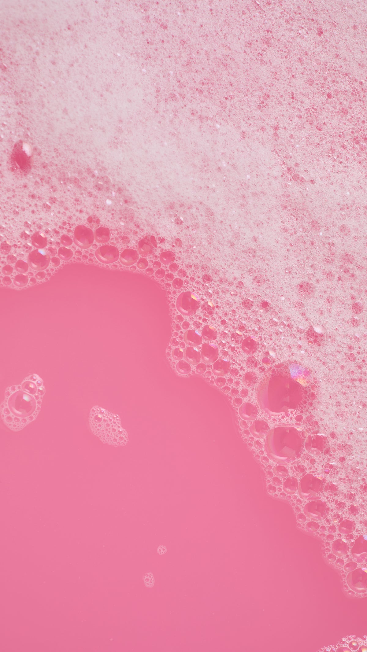Bright pink bath water edged with white bubbles from Candy Cane bubble bar.