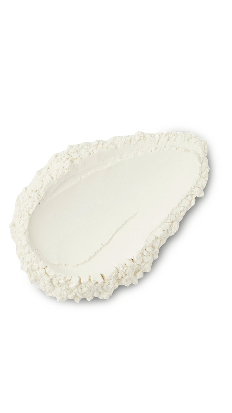 A cream coloured tear-shape swatch of a lush dusting powder.