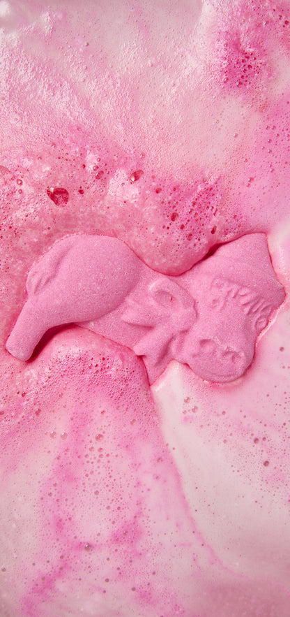 Pink Dominick The Donkey bath bomb dissolving into swirls of pink foam.