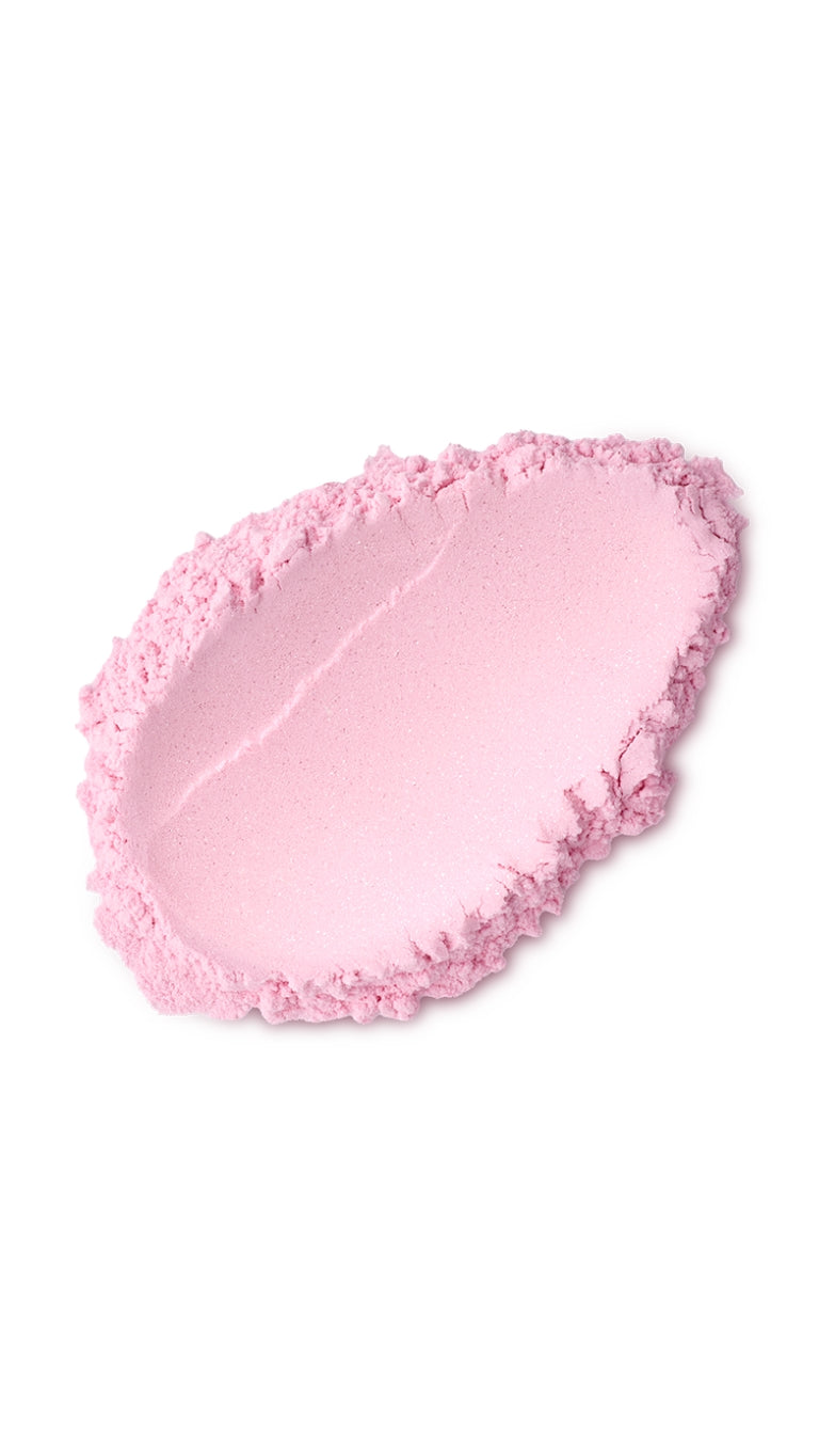 A pink tear-shaped swatch of a lush dusting powder. 