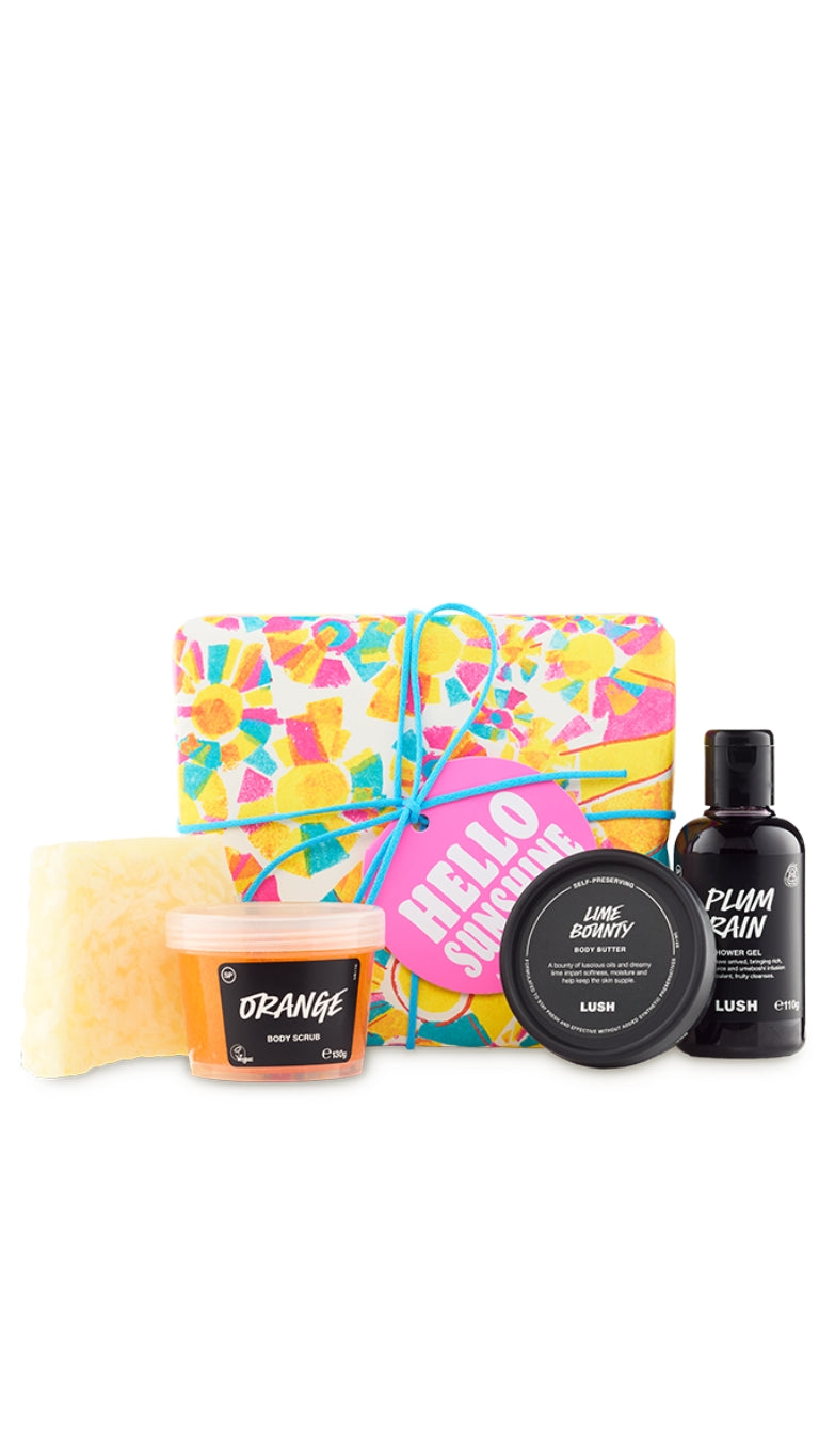Hello Sunshine Gift featuring Bohemian soap piece, Orange body scrub, Lime Bounty body lotion, and Plum Rain shower gel displayed in front of a vibrant and colourful patterned wrapped gift box.