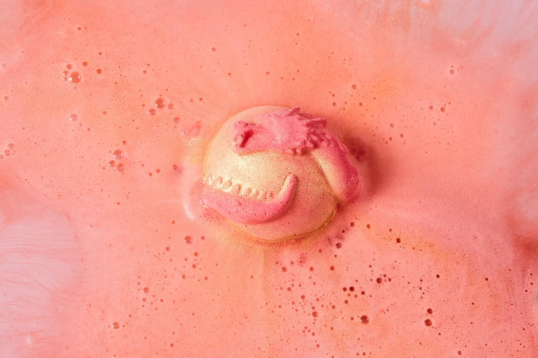 Inner dragon Lush Bath bomb fizzing in a bath. Swirls of oranges, peach and gold bath art.