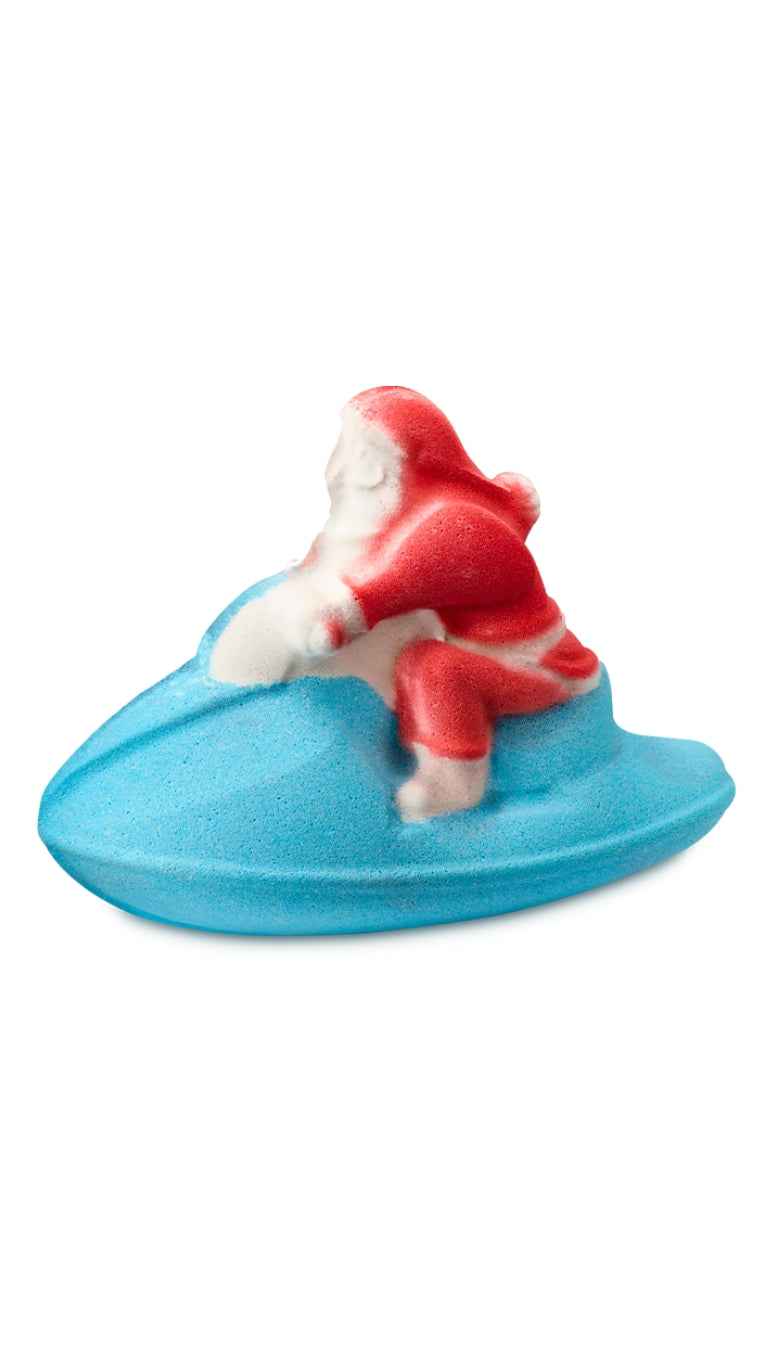 A red and white santa sitting on a blue jet ski-shaped bath bomb. 