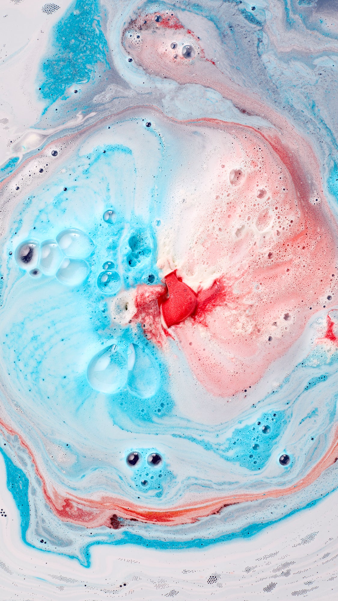 Jet Ski bath bomb creating blue, pink and white swirls of foam in the bath.