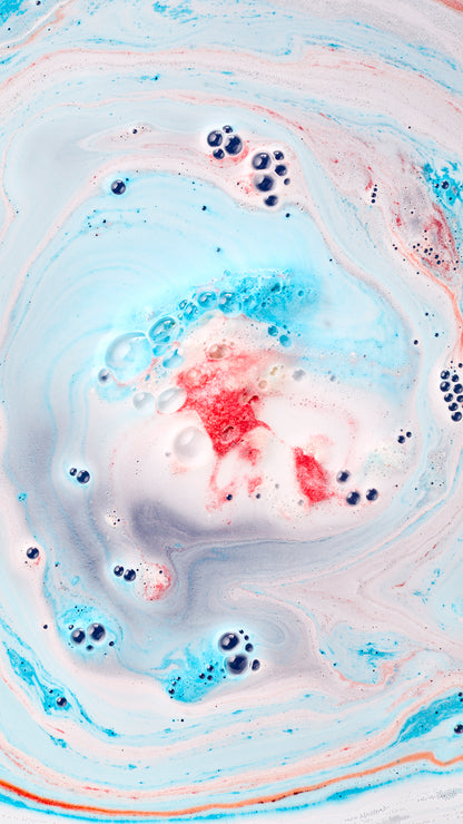 Red Santa figure from Jet Ski bath bomb surrounded by pastel blue and pink bath foam.