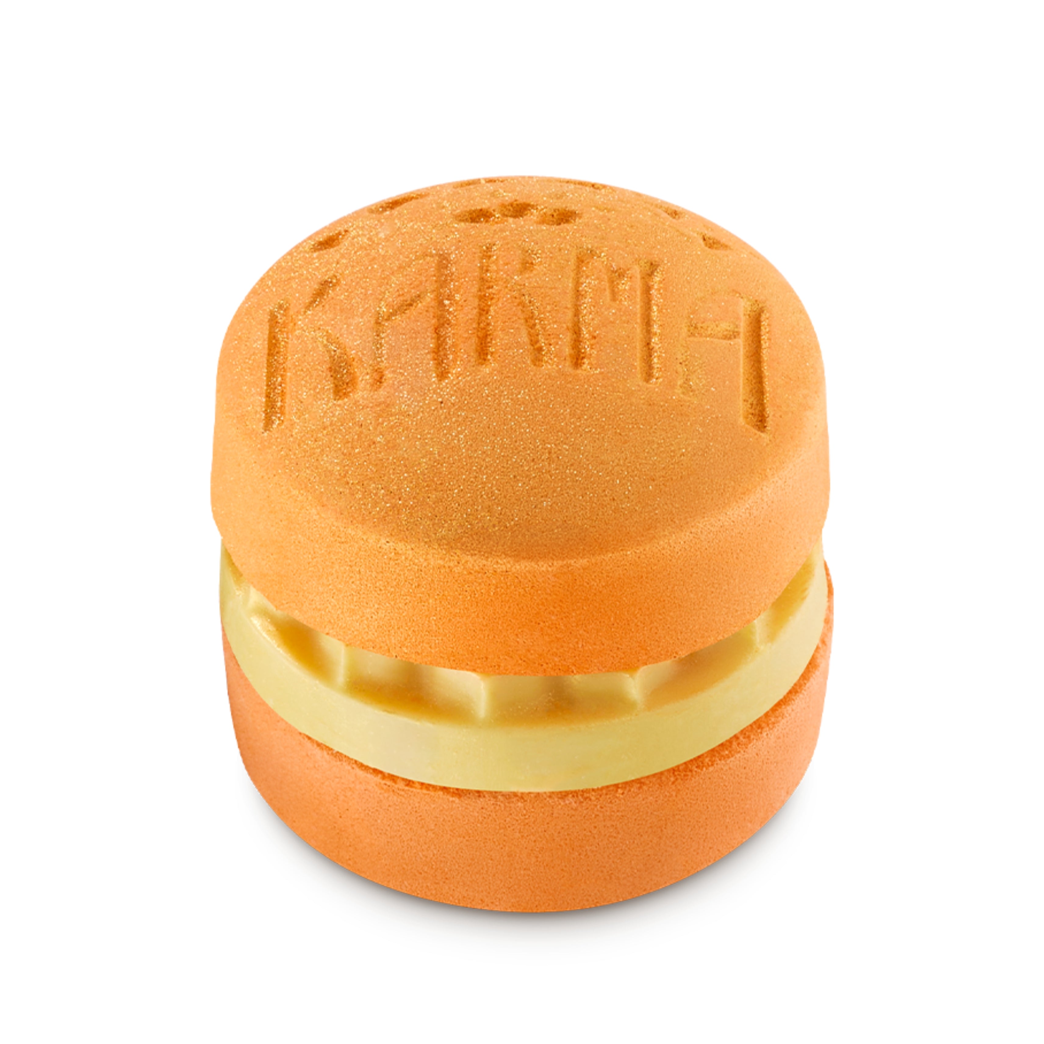 Orange macaron-shaped bath bomb with a nourishing bath oil layer in the center.
