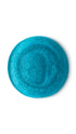 A blue iridescent circular swatch of a lush shower gel. 