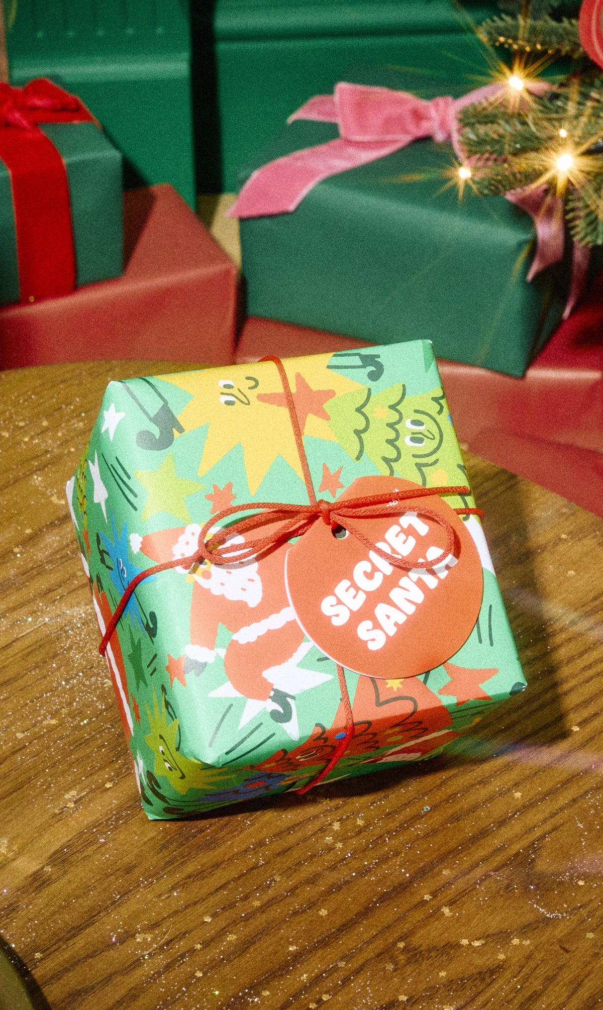 Secret Santa gift in illustrated green wrapping tied with orange string.
