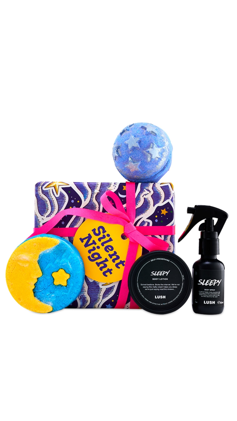 Silent Night gift featuring Sleepy body spray and body lotion, festive bath products, displayed around a purple wrapped gift box. 