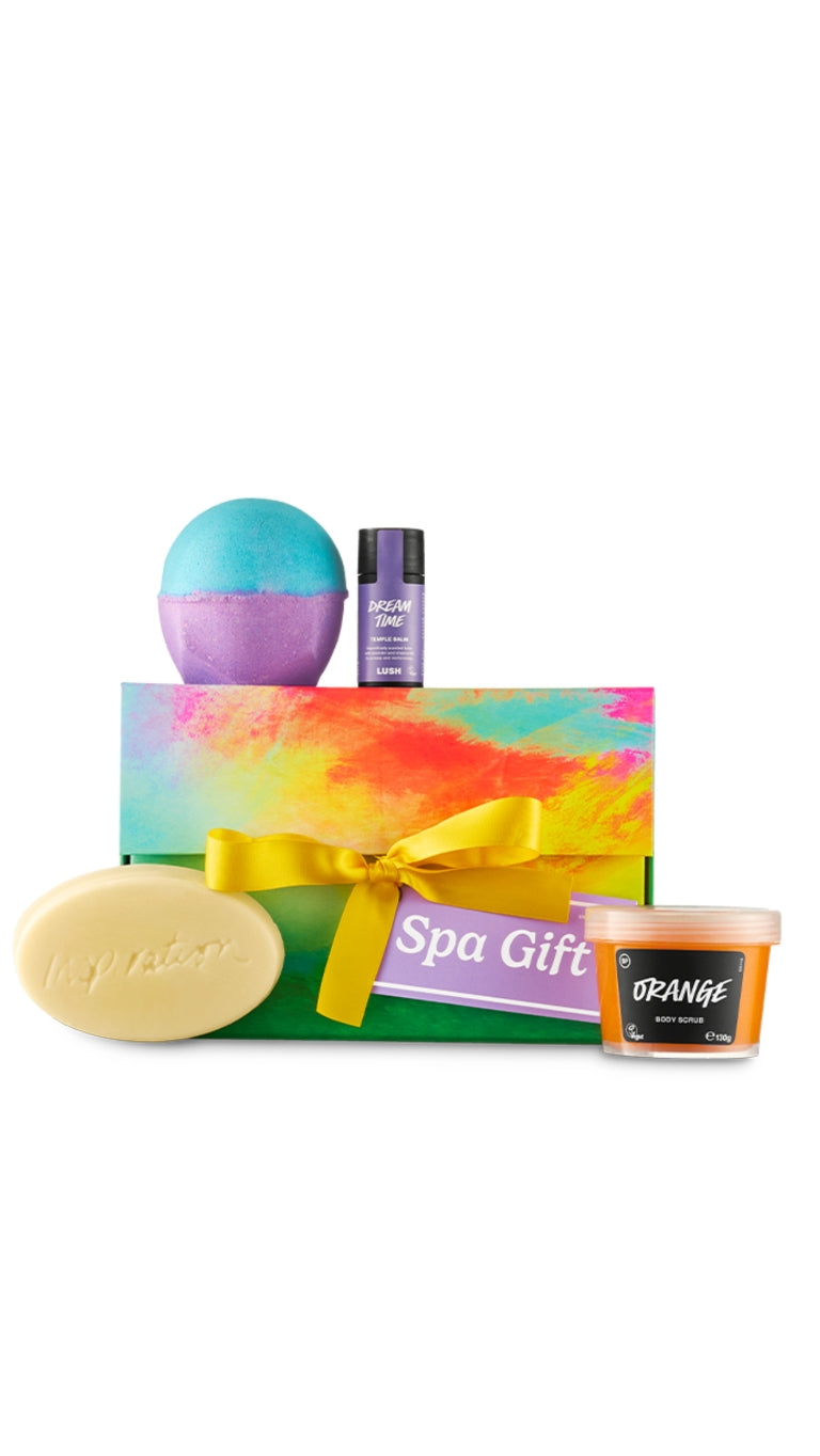 Spa Gift featuring Orange body scrub, Dreamt Time temple balm, and Inspiration massage bar and both bomb exclusives displayed around a vibrant and colourful marbled flip-top gift box. 