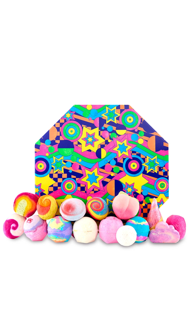 The Art of Bathing Gift featuring a large variety of vibrant and colourful bath bombs displayed in front of a multi-pattern and graphic hexagon-shaped hat box. 